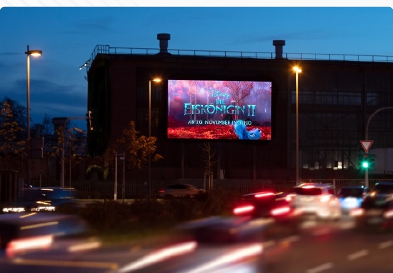 Outdoor LED display operating beside a city road at night